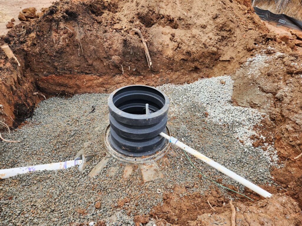 Septic tank access riser set in gravel with inlet and outlet lines, Carolina Septic, CSRA